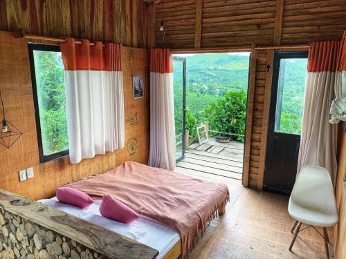 a bedroom with a bed and a large window at Năm mùa Bungalows in Hương Hóa