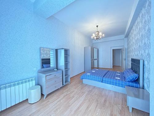 Dormitorio azul con cama y espejo en White Stone Residence 47 en Bakú