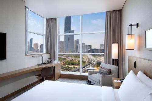 a hotel room with a bed and a desk and a window at Courtyard by Marriott Riyadh Northern Ring Road in Riyadh