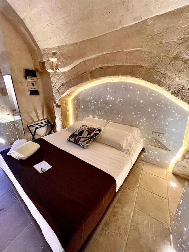 a bedroom with a bed in a stone wall at CASA VACANZE BB 164-166 in Matera