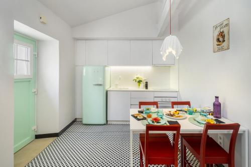 una cucina con tavolo, sedie e frigorifero di Wonderland Leiria a Leiria