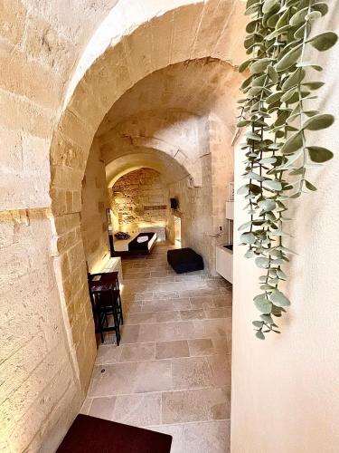 a hallway in a stone building with a table and a plant at CASA VACANZE BB 164-166 in Matera
