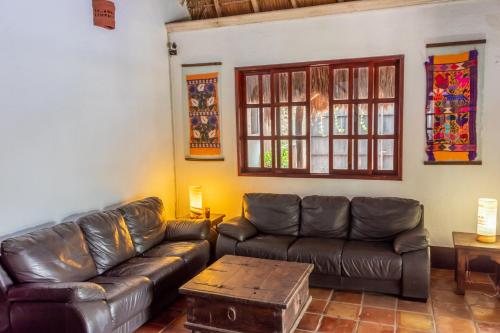 a living room with a leather couch and a table at Bed & Breakfast Casaejido in Playa del Carmen