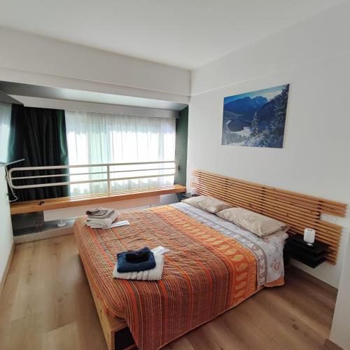 sypialnia z dużym łóżkiem i oknem w obiekcie Genziana Apartment w mieście Marilleva