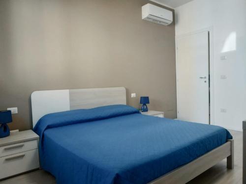 um quarto com uma cama com um cobertor azul em Modern Central Apartment em Grottammare