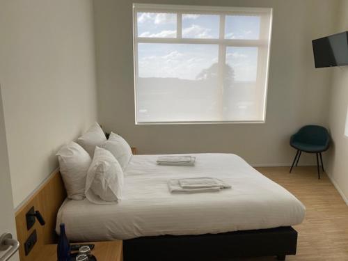 Cama en habitación con ventana en Hotond Sporthotel en Kluisbergen