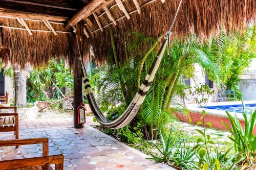 - un hamac suspendu au toit de chaume dans un complexe dans l'établissement Bed & Breakfast Casaejido, à Playa del Carmen