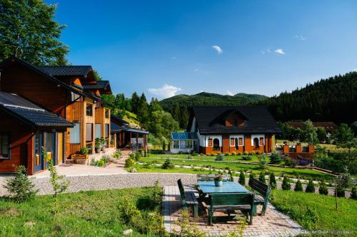a house with a table and chairs in a yard at Rita Art Chalet Voronet in Voroneţ