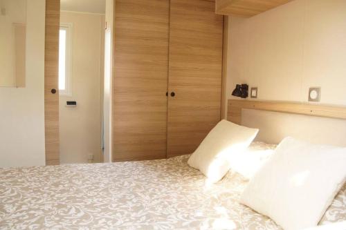a bedroom with a bed with two pillows at Modern holiday Chalet on lake side holiday park in Lauwersoog