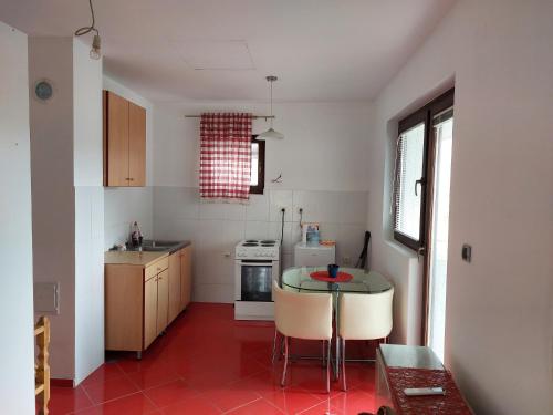 een keuken met een rode tegelvloer en een tafel bij Belanovica in Belanovica
