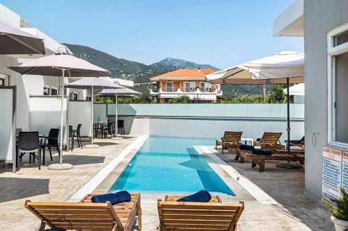 a pool at a hotel with chairs and umbrellas at Papatsas Center Houses in Nydri
