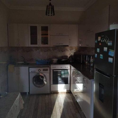 a kitchen with a washing machine and a refrigerator at Guest House Violeta in Gonio