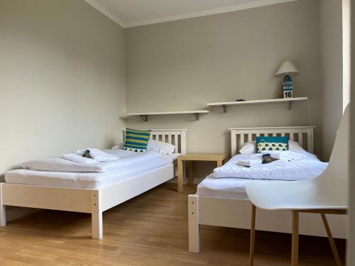 Zimmer mit 2 Betten, einem Tisch und Stühlen in der Unterkunft Jaardenhuug - EG in Utersum