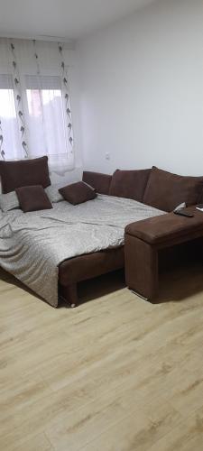 um quarto com uma cama grande e um sofá em Apartman Vanja em Paraćin