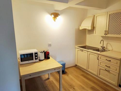 a kitchen with a table with a microwave on it at Genziana Apartment - CIPAT 22114 in Marilleva