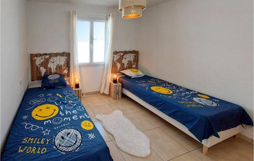 1 dormitorio con 2 camas individuales y sábanas azules en Nice Home In Sainte-gemme-la-plaine With Private Swimming Pool, Can Be Inside Or Outside, en Sainte-Gemme-la-Plaine