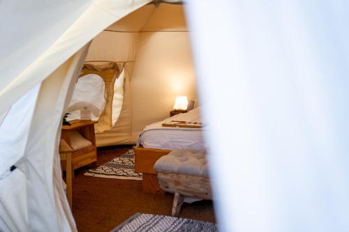 a room with a tent with a bed and a chair at Glamping Gozdna Jasa in Bovec