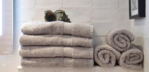 einen Stapel Handtücher auf einem Regal im Bad in der Unterkunft Campolo Apartment in Reggio di Calabria