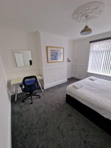 - une chambre avec un lit, un bureau et une chaise dans l'établissement Luna Apartments Newcastle Gateshead 1, à Gateshead