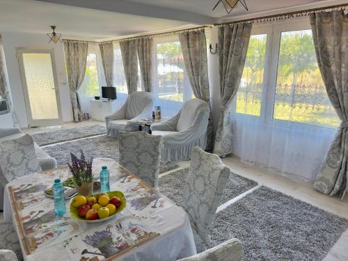 - un salon avec une table, des chaises et des fenêtres dans l'établissement Casa Andrei și Cătălin, à Tăşnad