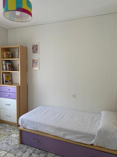 ein Schlafzimmer mit einem Bett und einem Bücherregal in der Unterkunft Casa Ameixeira in Carnota