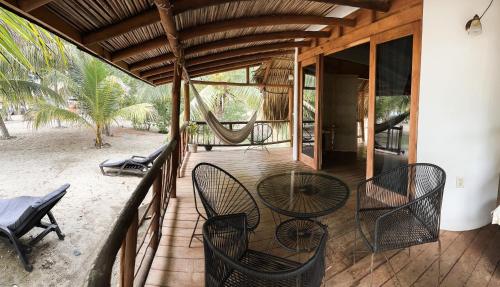 porche con mesa, sillas y hamaca en Los Bungalows de Blanca - Playa La Saladita, en La Majahua