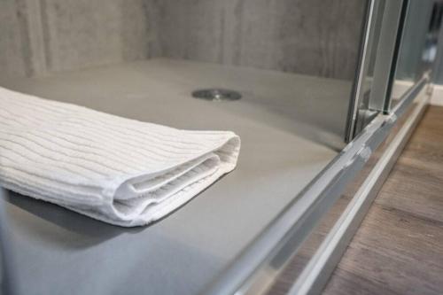 a white towel is sitting on a counter in a shower at Cucchiari Suite 1A in Modena