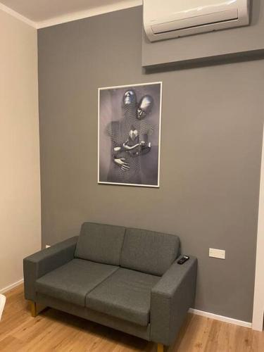 a couch in a living room with a picture on the wall at Cucchiari Suite 1A in Modena