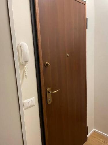 a wooden door with a phone on a wall at Cucchiari Suite 1A in Modena