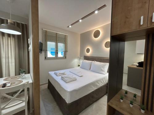 a small bedroom with a bed and a table at Armonía Small Luxury Apartments in Ierápetra