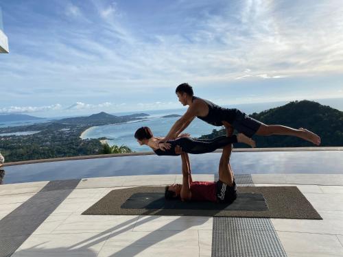two men doing yoga on the edge of a pool at Best world vision in Chaweng