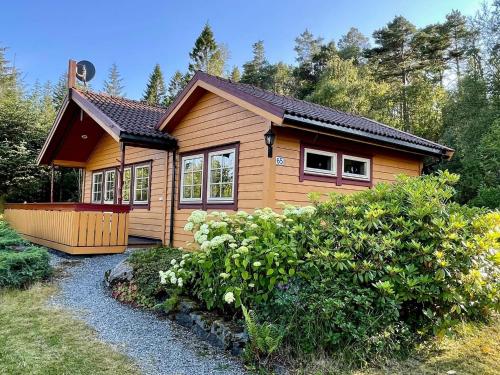 a small wooden house in the middle of a garden at Holiday home MOSTERHAMN V in Mosterhamn