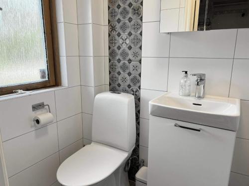 Baño blanco con aseo y lavamanos en Holiday home HUDDINGE III, en Huddinge