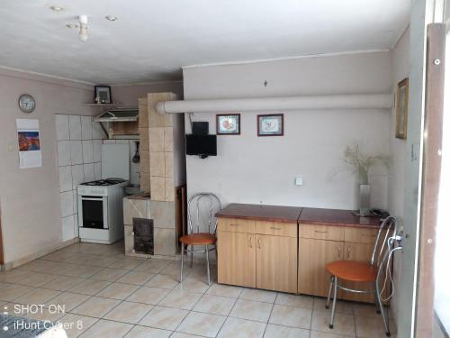 - une cuisine avec 2 chaises et un comptoir dans une pièce dans l'établissement Casa Pescarilor, à Tulcea