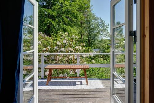 an open door to a deck with a bench outside at Peaceful getaway in the woods w/ fireplace in Åsljunga