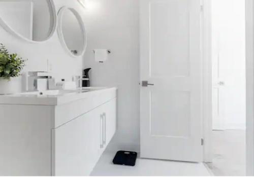 uma casa de banho branca com um lavatório e um espelho em Luxury Suite 4mins To Falls em Cataratas do Niágara