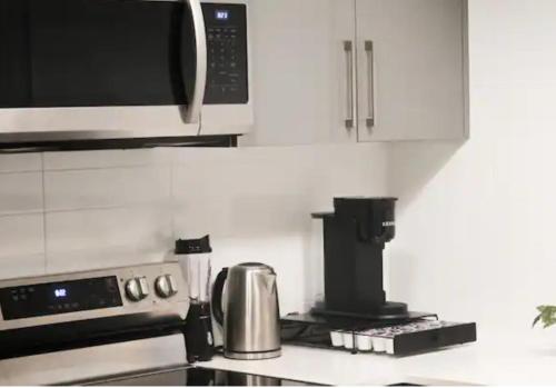 a kitchen with a microwave and a stove top oven at Luxury Suite 4mins To Falls in Niagara Falls