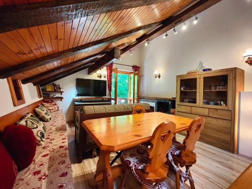 a living room with a wooden table and a couch at Hostdomus - Bouvier Apartment in Cesana Torinese