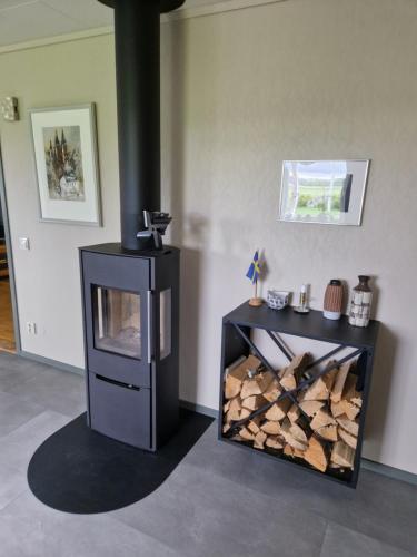 - une cheminée dans le salon doté d'une pile de bois dans l'établissement Lantlig villa utanför Uppsala, à Alunda
