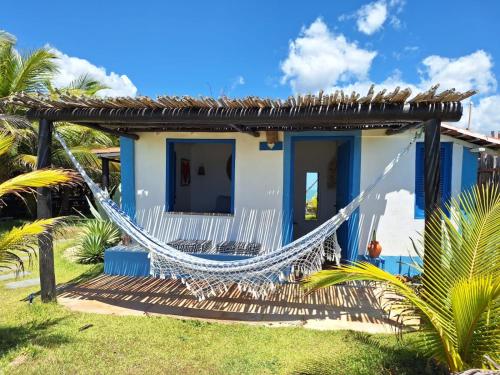 a house with a hammock in front of it at Pousada Casa Azul do Piauí in Luis Correia