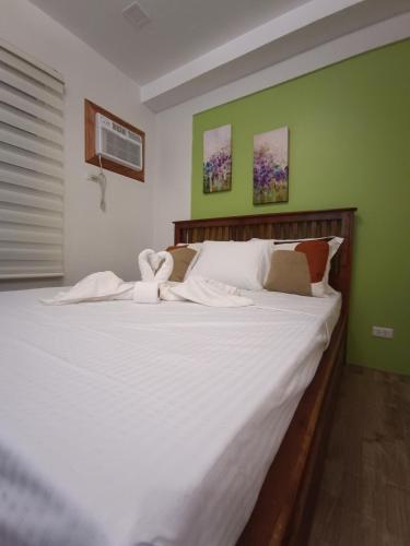 una camera da letto con un grande letto bianco con due cigni sopra di 3 J's STAYCATION a Bacolod