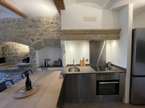 eine Küche mit einer Spüle und einem Kühlschrank in der Unterkunft Le Repaire du Pic, gîte de charme 3 étoiles in Notre-Dame-de-Londres