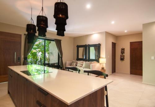 a kitchen with a counter and a living room at 2 bedroom apartment at Aldea Zama by Casago in Tulum