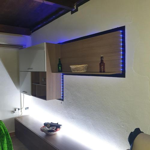 a kitchen with a shelf with bottles on the wall at b e b bascus argius in Cagliari