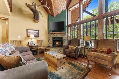 a living room filled with furniture and a fireplace at Makin Memories Lodge Cabin in Branson West