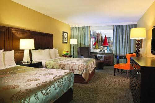 a hotel room with two beds and a window at Beddable Unit by The Excalibur Casino Las Vegas STRIP in Las Vegas