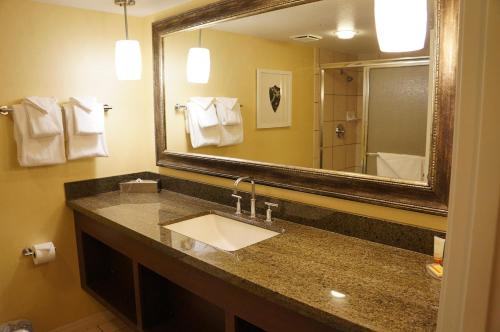 a bathroom with a sink and a large mirror at Beddable Unit by The Excalibur Casino Las Vegas STRIP in Las Vegas