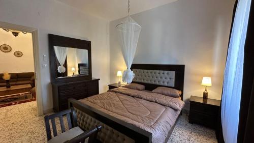 1 dormitorio con cama y espejo grande en The vintage apartment en Amán