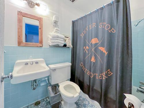 a bathroom with a toilet and a sink and a shower curtain at The Wanderoo Lodge in Eureka Springs