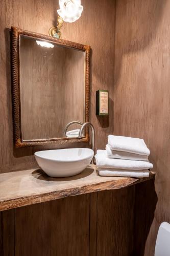 a bathroom with a sink and a mirror and towels at La Petite Ruelle in Durbuy